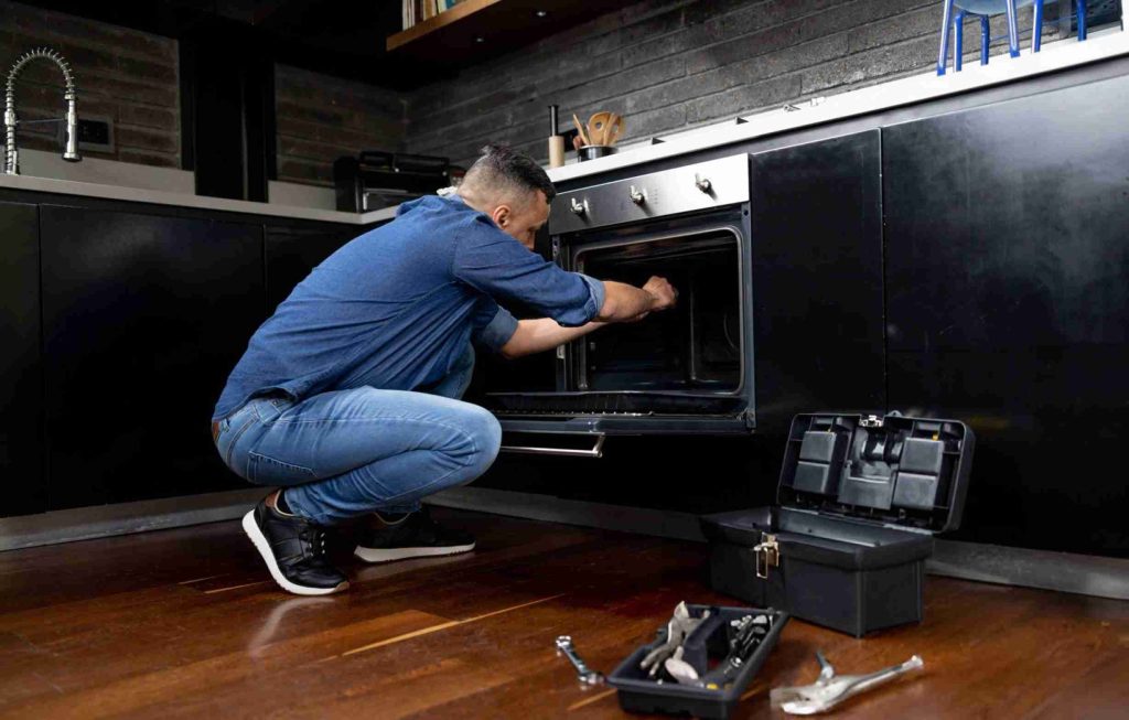 Electrician installing an oven at a house stock photo