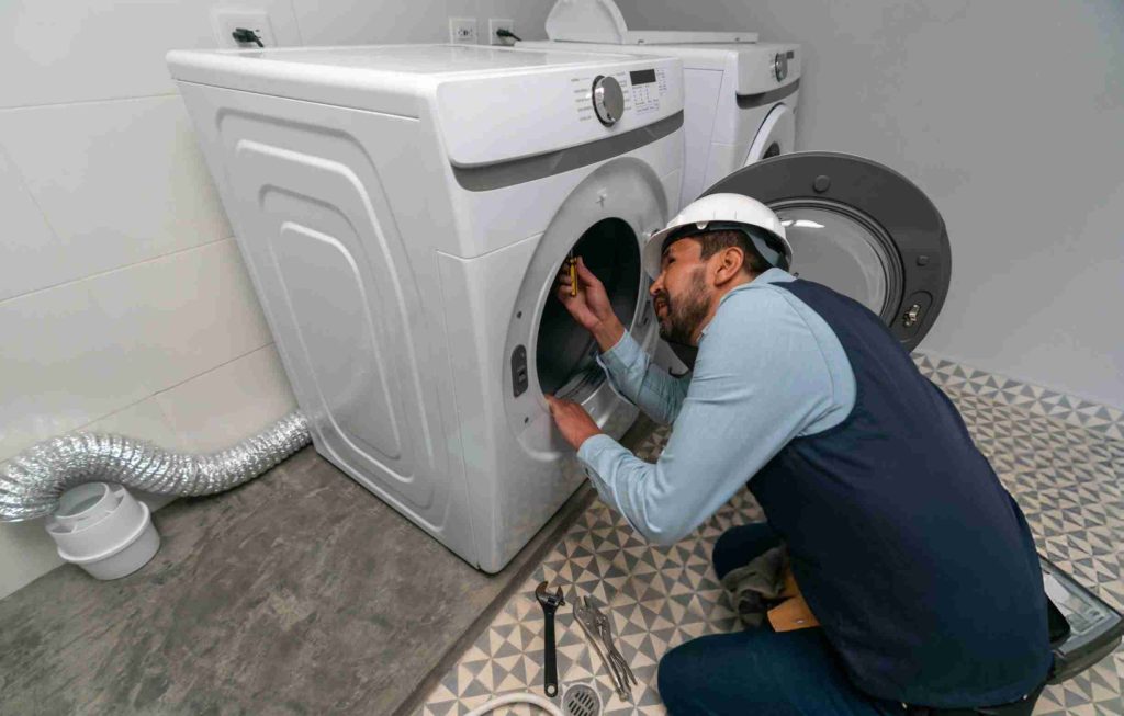 Handyman installing a washing machine at a house stock photo
